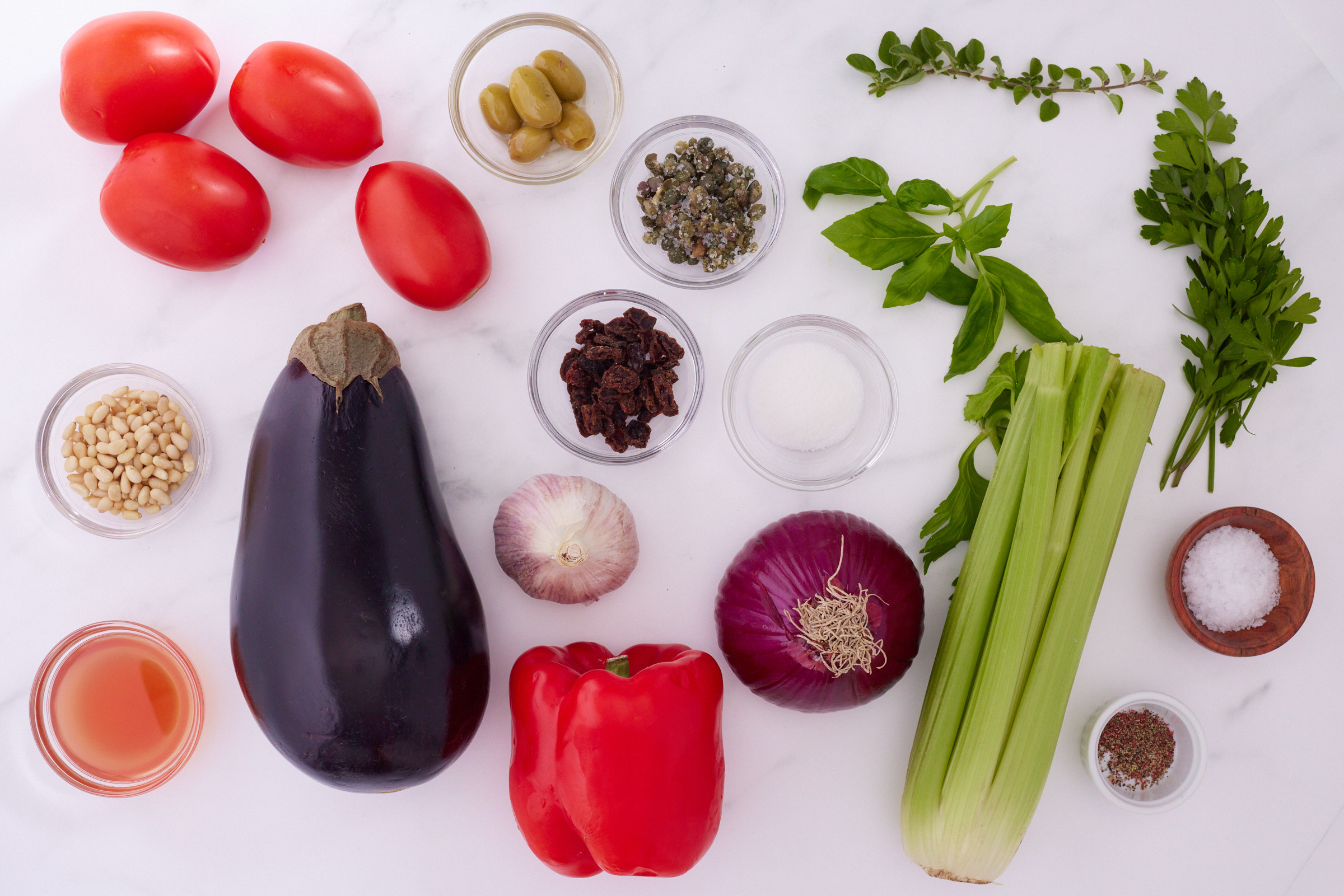 Ingredients for Sicilian caponata including eggplant, tomatoes, celery, peppers, olives and capers